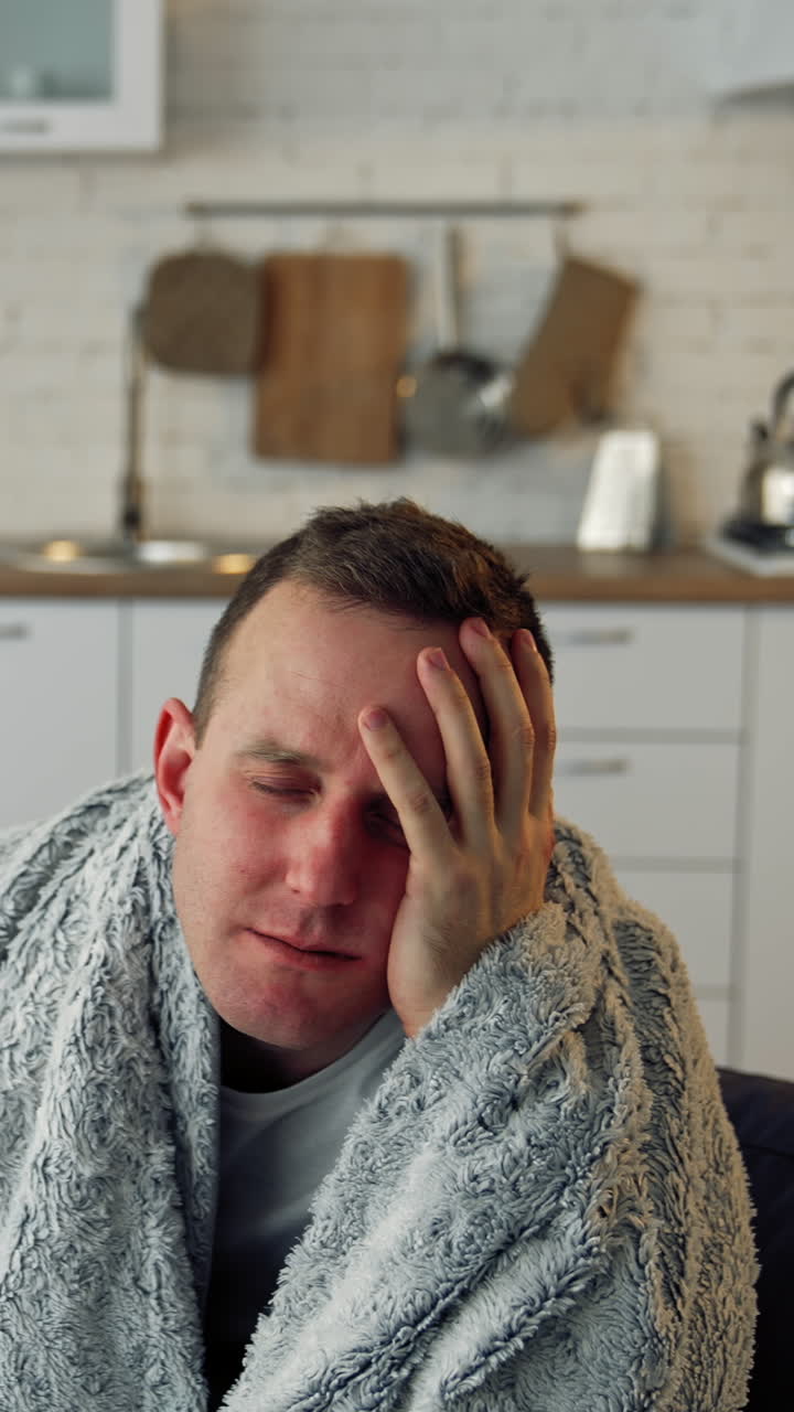 Sick young man suffering from flu at home. Pandemic. Quarantine concept. Vertical video