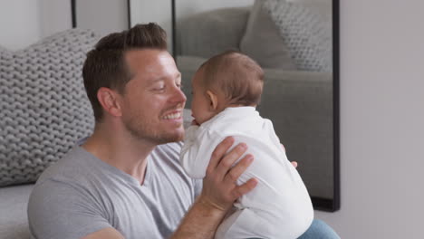 Vater-Hält-Seine-Kleine-Tochter-In-Die-Luft-Und-Schneidet-Grimassen,-Um-Sie-Zum-Lachen-Zu-Bringen