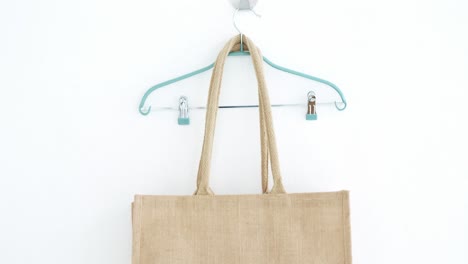 handbag and hanger hanging on white wall