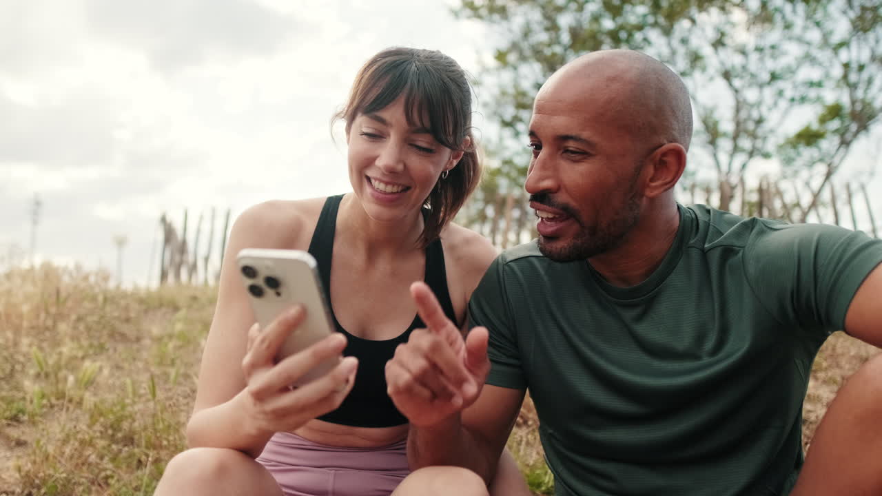 Happy Couple Discussing Content on Smartphone Outdoors