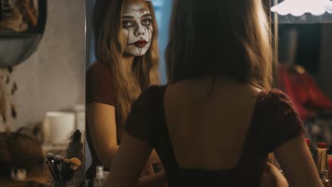 girl with halloween makeup looking in mirror