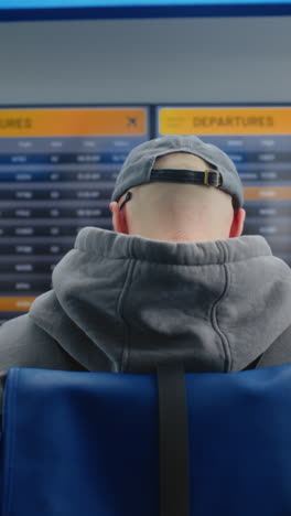 hombre comprobando la información de vuelo en el aeropuerto
