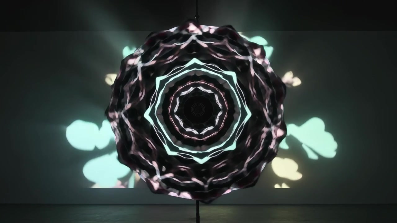 Projecting suspended mandala pulsing in gallery with light starting for exhibition, disc cable