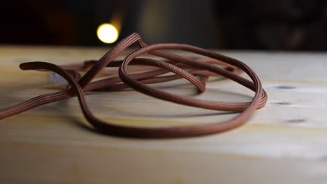 green paracord with white tendons on a wooden board with a dark background