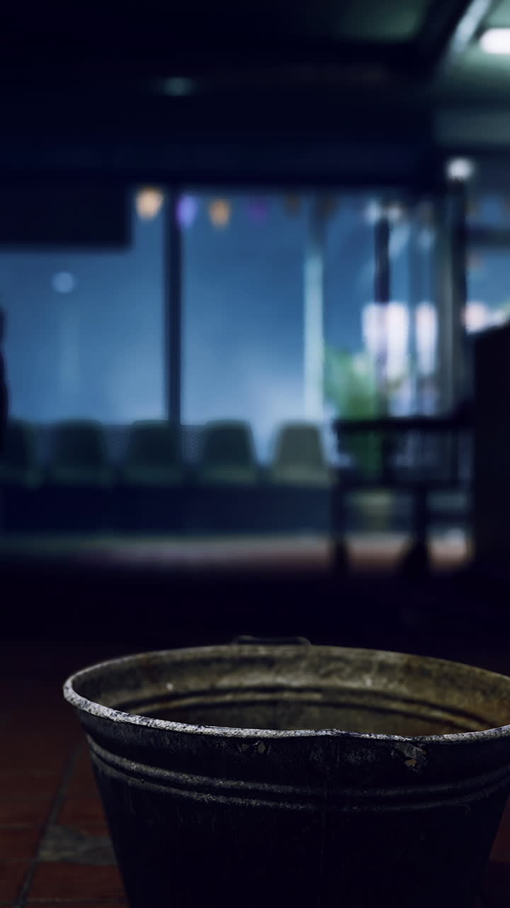 Mysterious bucket in a dimly lit laundromat at night
