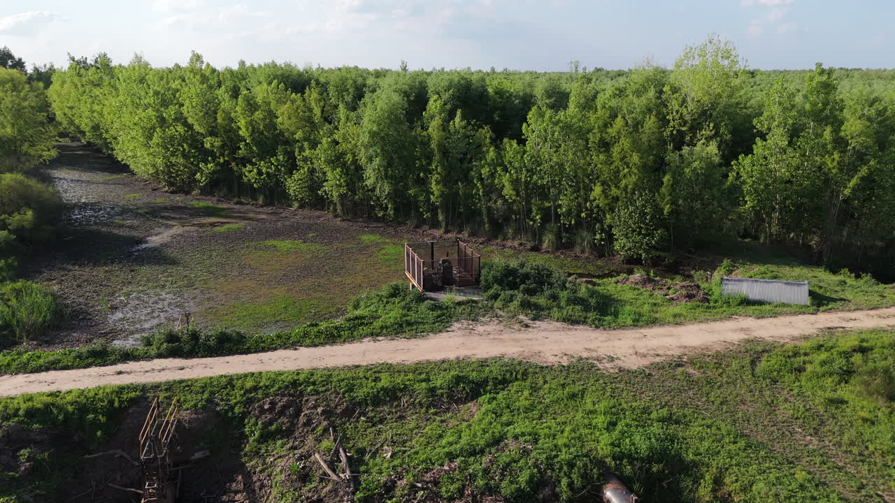 Rural irrigation system crossing forest road seen from drone aerial perspective