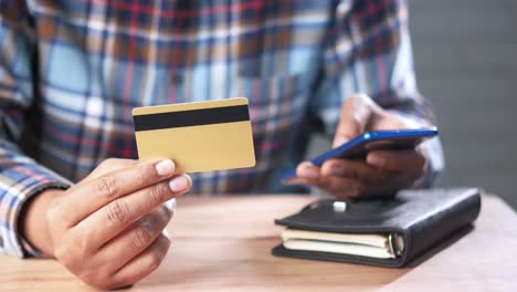 person using credit card and smartphone for online payment