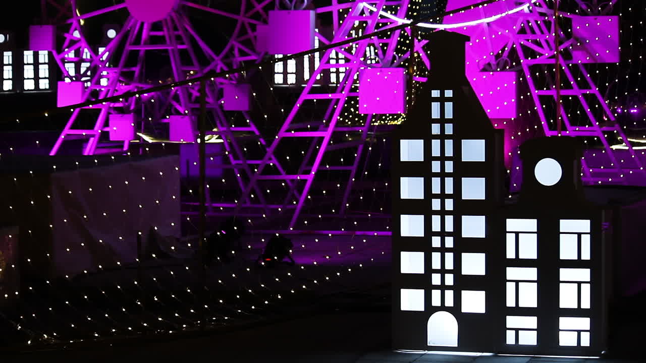 보라색 조명이 있는 소형 관람차의 자른 보기