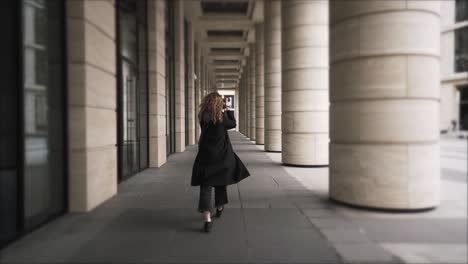 woman walking through a colonnaded city street