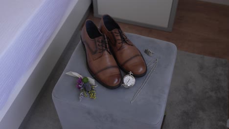 brown leather shoes with wedding accessories on a soft velvet ottoman