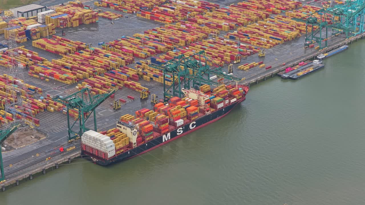 Drone panorama of busy port terminal with cranes, ships and containers