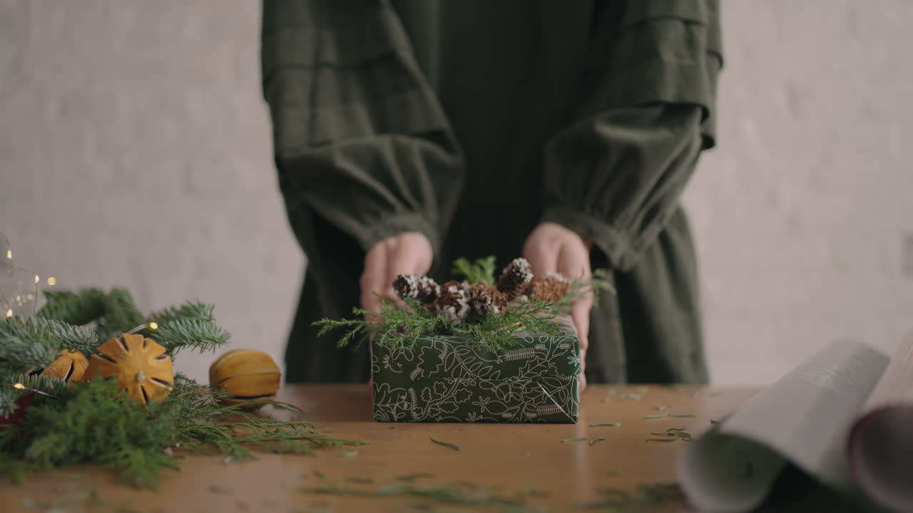 Zoom camera and girl in hand holds a Christmas present and moves it towards the camera