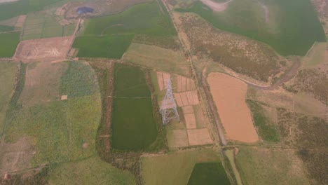 aerial of rural bangladesh with rice paddy fields and electric pylon