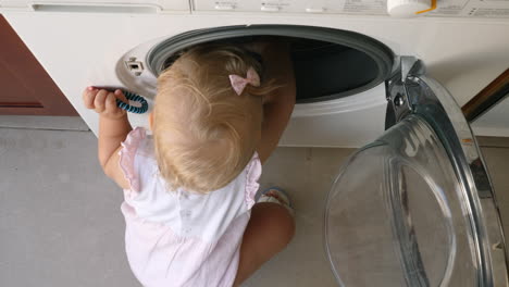 little child exploring the washing machine