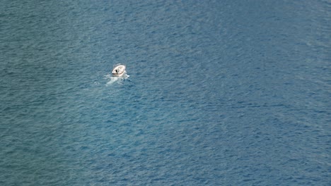 A-lonely-boat-is-sailing-in-the-middle-of-the-sea-in-Capri,-in-Italy