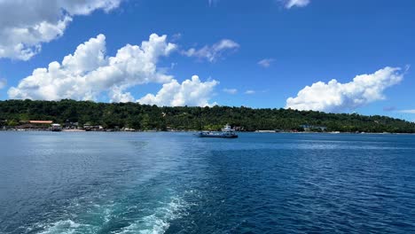 a ferry cruises past a lush tropical shoreline under a vibrant blue sky—ideal for travel, nature, or marine-related projects