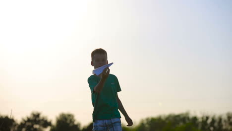 paper airplane in child hand. happy little girl putting a paper airplane near factory