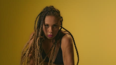 Expressive-woman-with-afro-dreadlocks-dancing-in-studio-front-camera