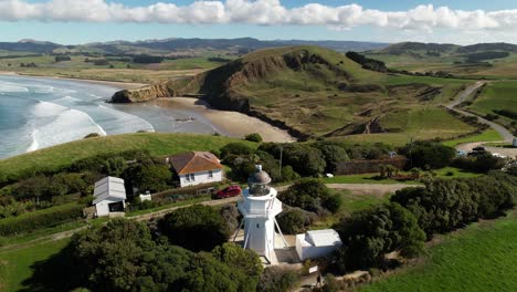 katiki point lighthouse drone reveal of tourist attraction and east coast scenery of new zealand