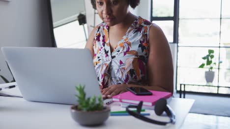 African-american-female-plus-size-vlogger-sitting-using-laptop