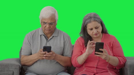 old indian couple busy in their phones green screen