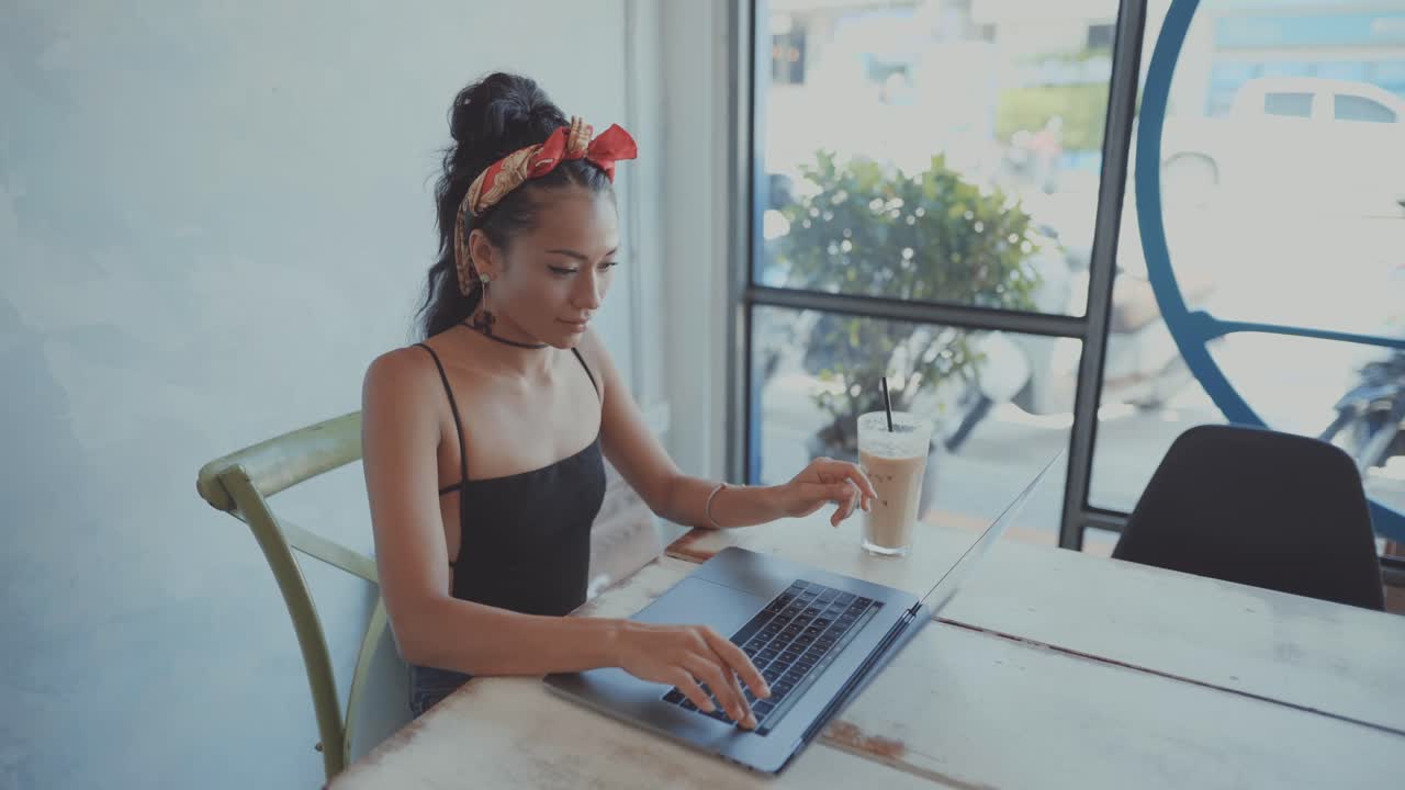 Woman Working on Laptop in a Cafe