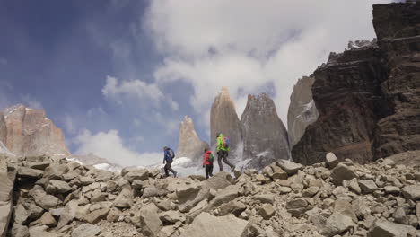 people hiking up rocky terrain in mountain wilderness in cloudy day