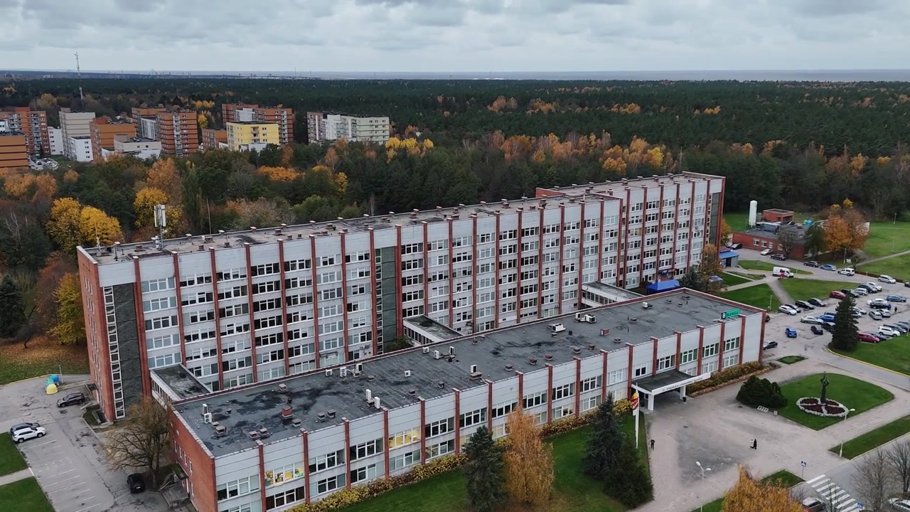 Klaipeda Hospital med omkringliggende efterårstræer og nærliggende beboelsesejendomme, luftfoto.