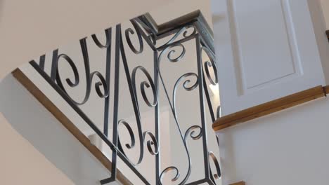 close up view of staircase railing with curled metals inside beautiful modern home