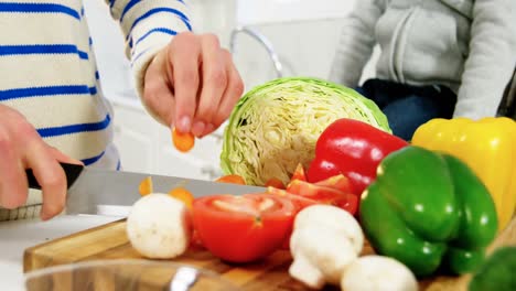 Boy-looking-while-father-chopping-vegetables