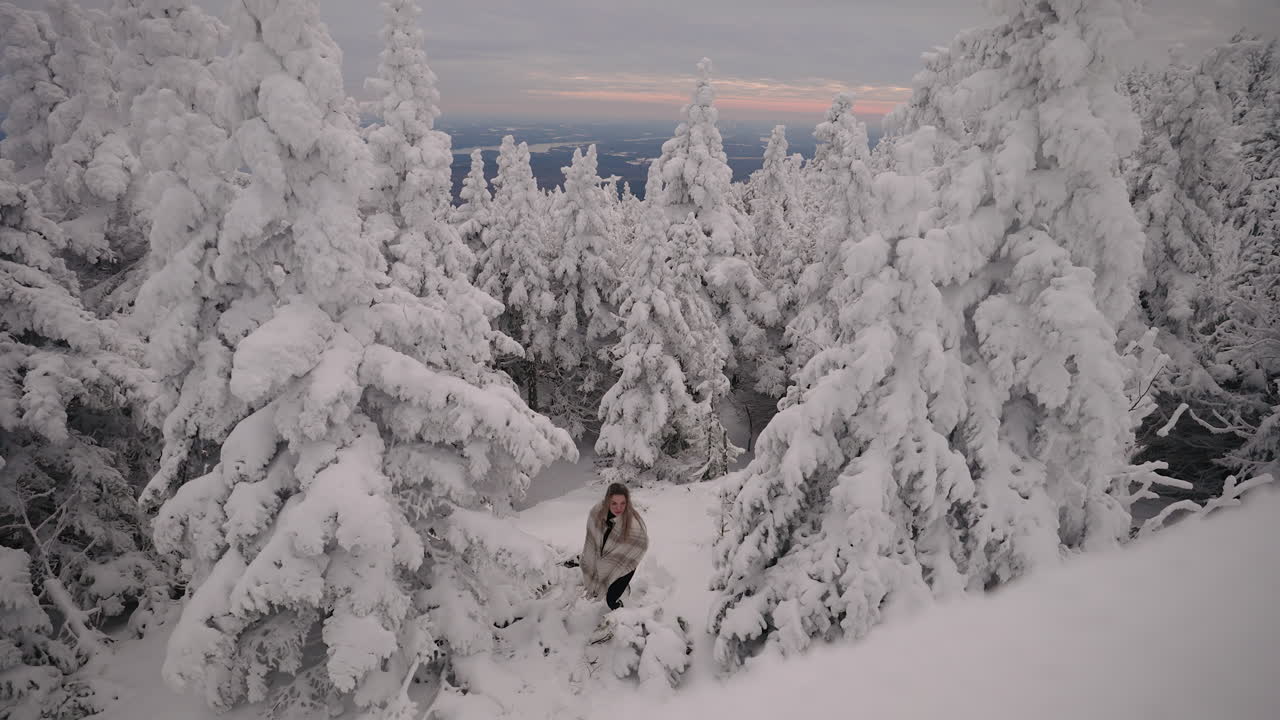 niña caucásica con chal vagando en la estación de esquí con árboles coníferos cubiertos de nieve en el monte orford, quebec, canadá