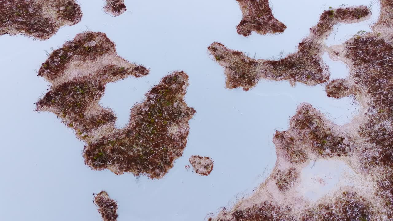 Slow top down aerial shot of frozen Cena bog showing icy natural textures