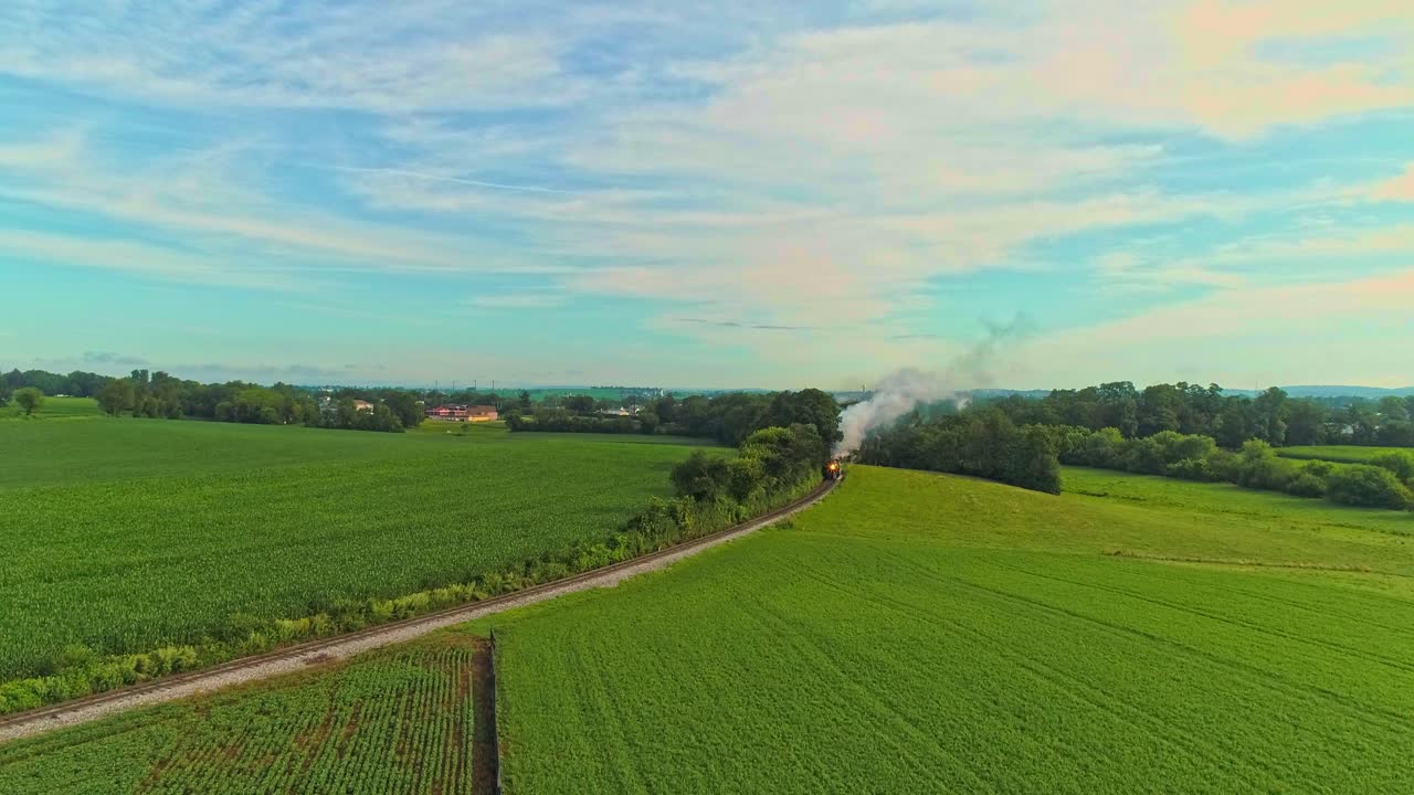 Aerial Landscape of Farmlands and a Antique Steam Engine Passes Thru the Corn Fields on an Early Summer Morning