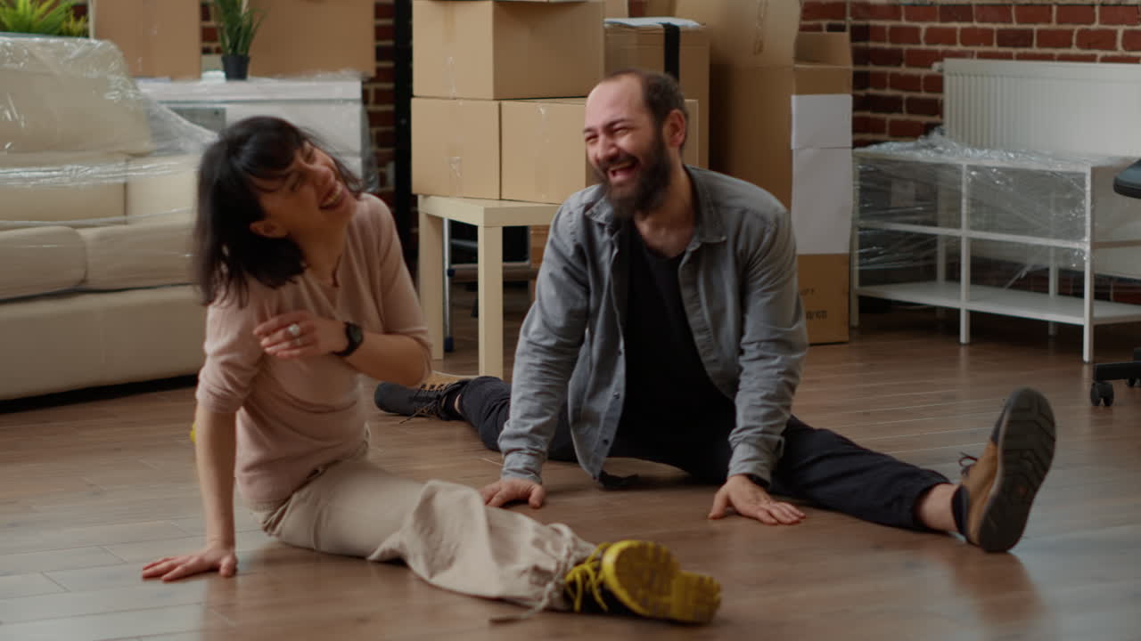 Married couple dancing together in living room flat after moving in