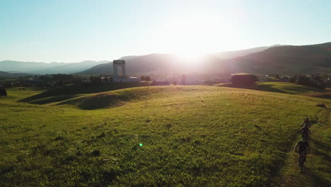 Group-of-mountain-bikers-on-off-road-grass-trail-ascending-up-the-hill