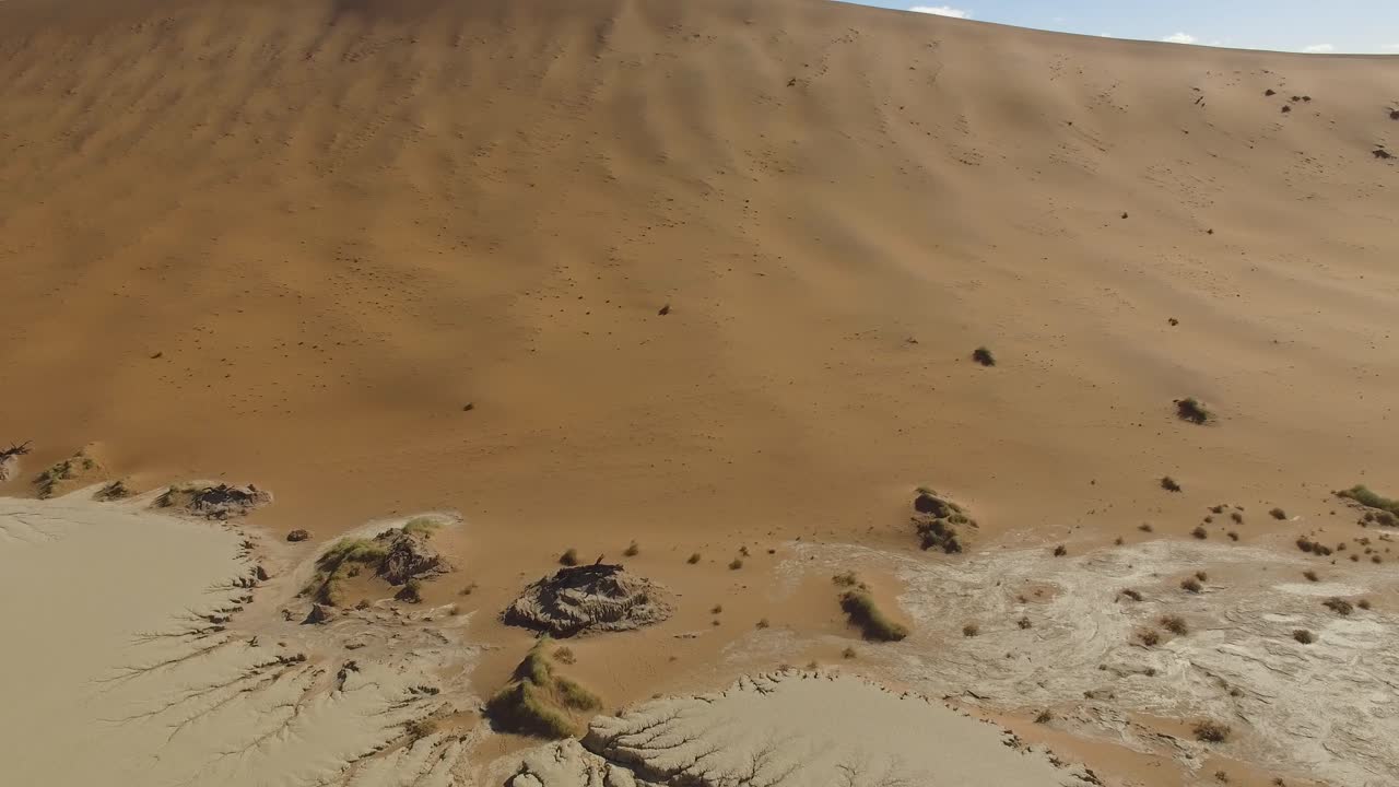 Dried soil and red dunes from the sky, aerial shot at Sossusvlei in Namib Desert, Namibia