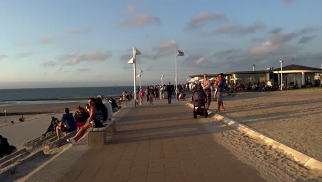 sunset at the beach: people relaxing and enjoying the evening