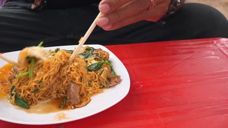 Toma-En-Cámara-Lenta-De-Comer-Comida-Callejera---Fideos-Fritos-Con-Huevo