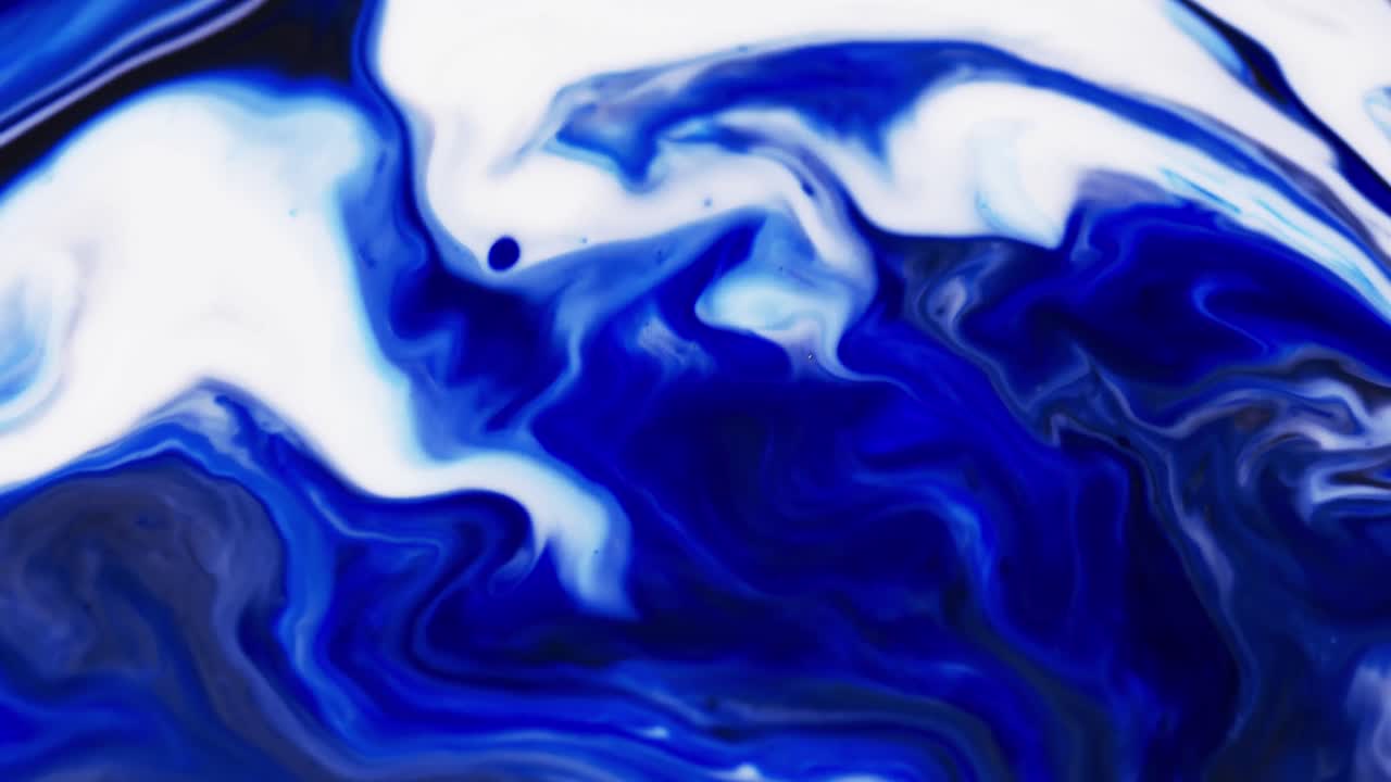 Video ravvicinato di inchiostro blu e bianco in acqua con spazio per il testo.