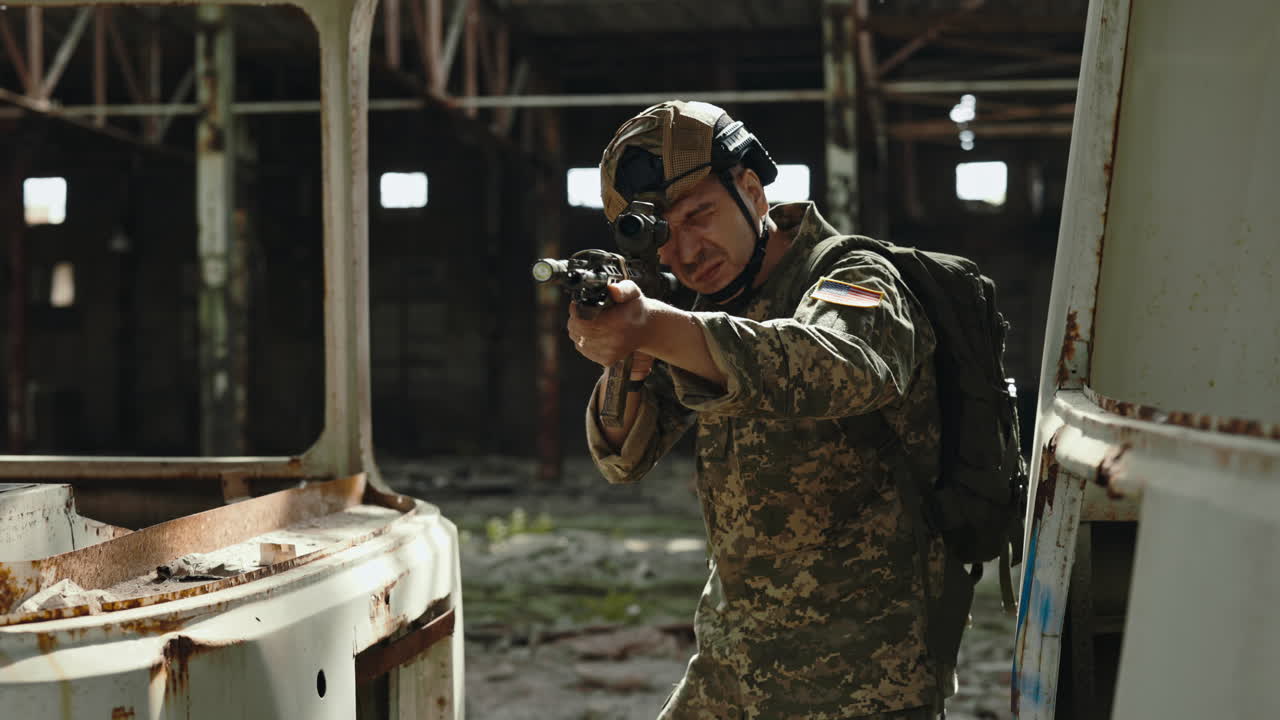 Soldier in Camouflage Uniform with Rifle in a Ruined Building