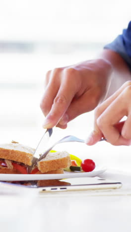 man eating lunch with drink in office