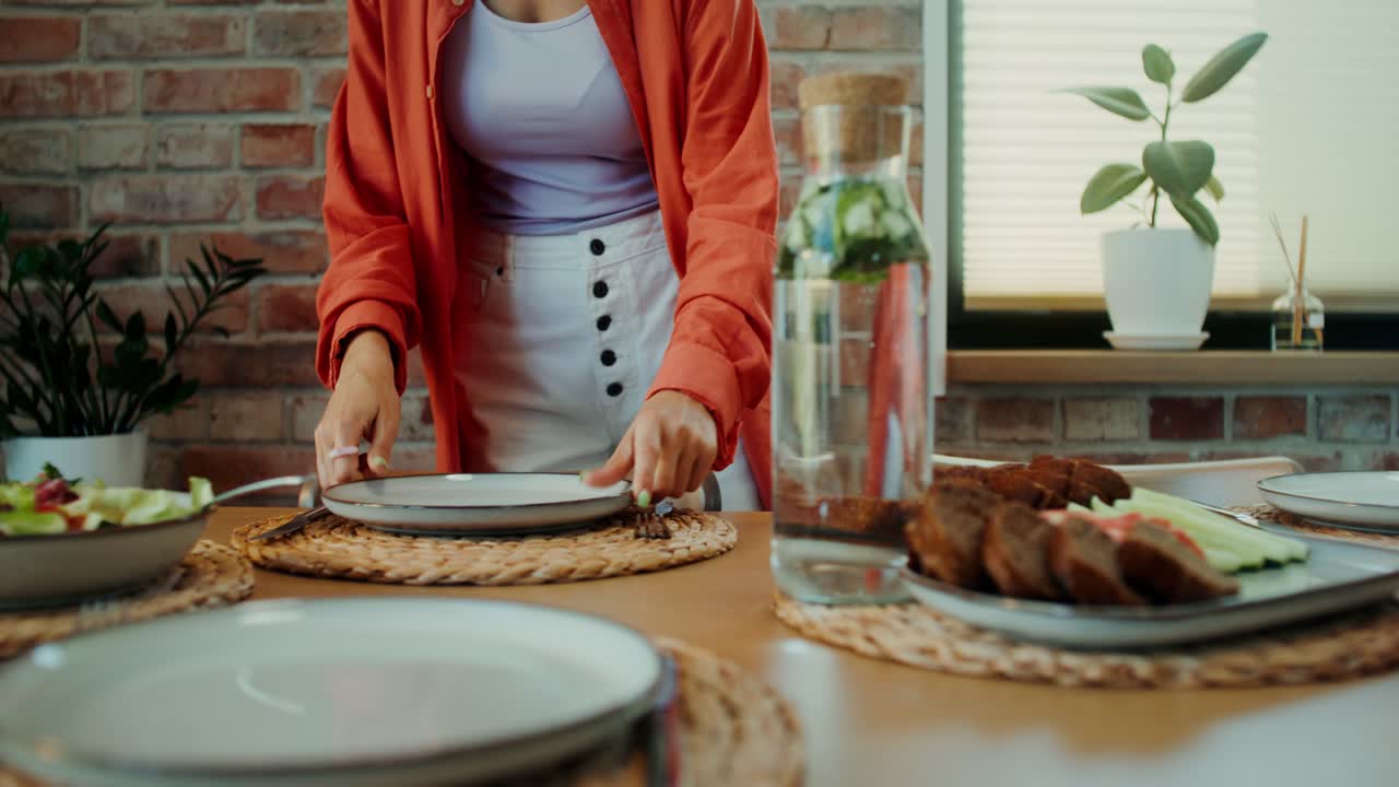 mujer preparando una mesa para una comida