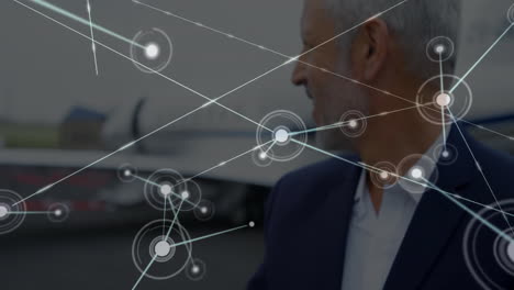 standing near airplane, man with network connections animation around him