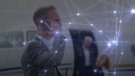 Animation-of-network-of-connections-over-caucasian-businessman-talking-on-smartphone