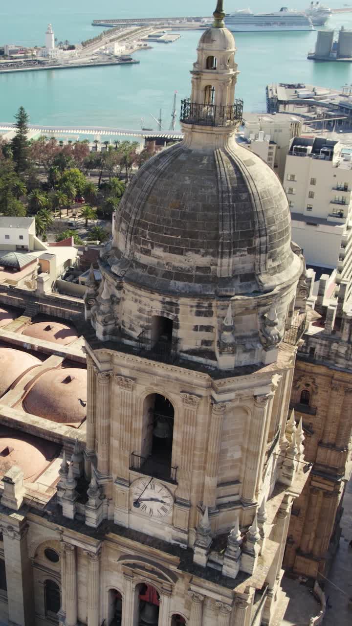 Orbita aerea verticale che cattura il campanile della Cattedrale di Malaga con ampie vedute della costa e della città sottostante