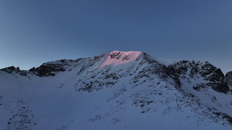 Drone-shot-underneath-Musala-peak-during-sunrise,-dawn,-Bulgaria,-Rila-mountain,-highest-summit-on-the-Balkans,-clear-weather,-clear-sky,-amazing,-stunning-view,-sunny-slopes