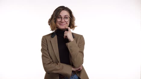 European-pretty-woman-in-stylish-glasses-and-brown-jacket-looks-confused-and-thoughtful-then-gets-an-idea.-Beautiful-young-woman-gets-excited-after-remembering-something,-pointing-up-with-a-finger