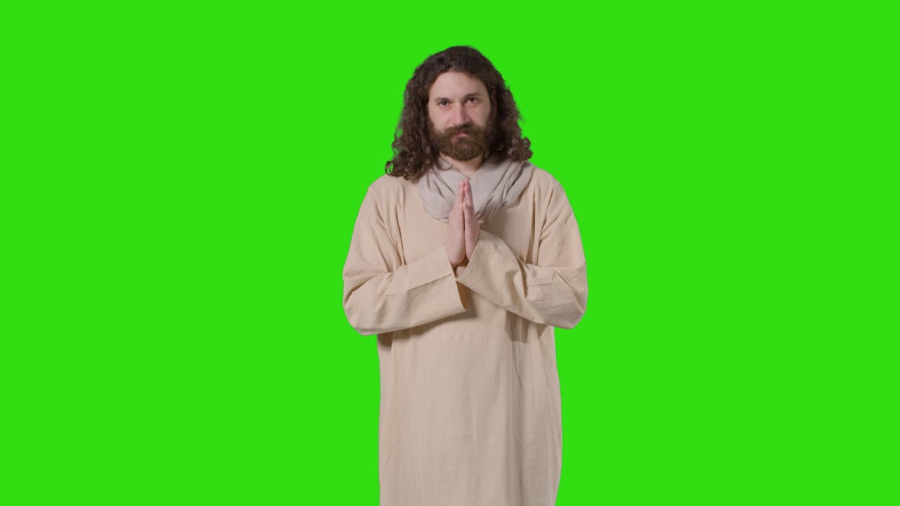 초록색 스크린 에서 기도 하는 예수 그리스도 의 형상 을 나타내는 긴 머리 와 수염 을 가진 옷 을 입은 사람 의 스튜디오  ⁇