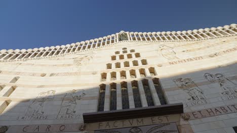 skyward pan across carved stone facade of annunciation basilica israel