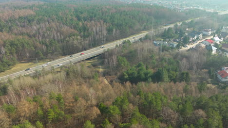 Belebte-Autobahn-Zwischen-Dichten-Wäldern-Mit-Leichtem-Dunst-Von-Der-Sonne